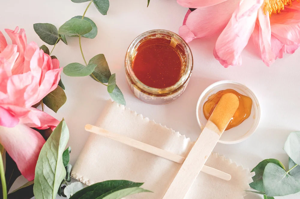 Waxing treatment surrounded by soft pink flowers